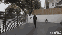 a woman is standing in a driveway with the words made in animatica on the bottom right