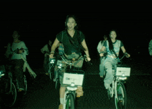 a woman is riding a bike with a sign on the front that says ' o ' on it