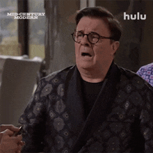 a man wearing glasses and a robe with hulu written on the bottom right