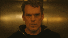 a close up of a man 's face with a black shirt on
