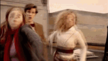 a man and two women are walking in a blurry photo