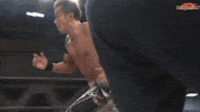 two men are fighting in a boxing ring with a referee in the corner