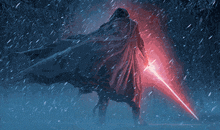 a man in a cape holding a red lightsaber in the snow