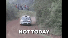 a rally car is driving down a dirt road with the words not today written on it .