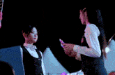 a woman wearing a headband is being touched by another woman .