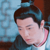 a man with a bun on his head looks at the camera