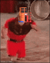 a man in a red shirt and red shorts is dancing in front of a drum set