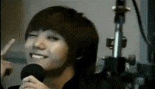 a young man is holding a microphone and smiling .
