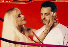 a woman touches a man 's face while he talks on his phone