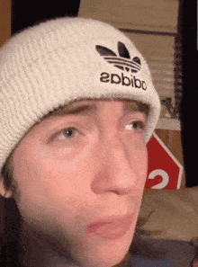 a person wearing a white beanie that says apbibo