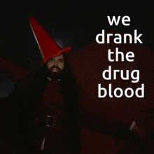 a man in a red hat stands in front of a sign that says " we drank the drug blood "