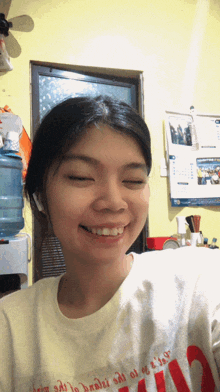 a woman wearing a shirt that says ' i love you ' on it smiles with her eyes closed