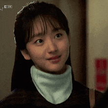 a woman wearing a turtleneck and a scarf around her neck