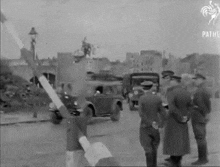 a black and white photo of a group of soldiers standing on a street .