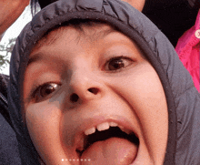 a close up of a child 's face with his tongue hanging out