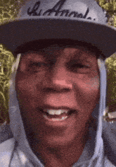 a man wearing a hat that says hi annal is smiling
