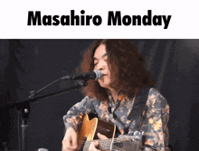 a man playing a guitar and singing into a microphone with the words masahiro monday below him