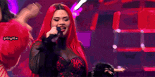 a woman with red hair sings into a microphone