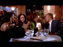 a man in a suit and tie sits at a table with two women