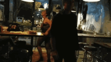 a woman in a black dress is dancing in a restaurant