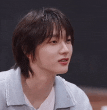 a close up of a young man 's face with short hair and bangs .
