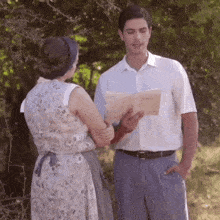 a man and a woman are standing next to each other and the man is holding a book that says " l' amour "
