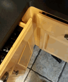 a corner of a yellow cabinet with a black counter top