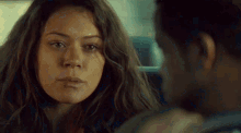 a man and a woman looking at each other in a car