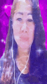 a woman is wearing headphones and looking at the camera .