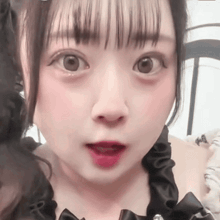 a close up of a girl 's face with her mouth open and her eyes looking at the camera .