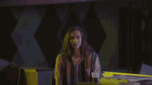 a woman with long hair is sitting at a table with a glass of beer in front of her .