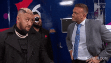 a man in a suit talks to another man in front of a sign that says " once a lion "