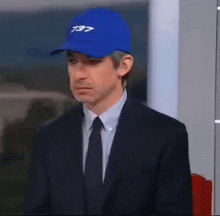 a man in a suit and tie wearing a blue hat that says 737