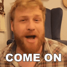 a man with a beard says come on in front of a chair