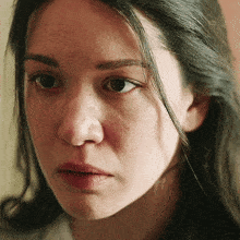 a close up of a woman 's face with a tear coming out of her eye