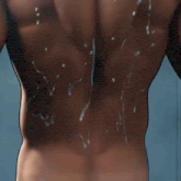a shirtless man is wrapped in a towel with water coming out of his arm