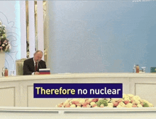 a man sits at a table with a sign saying contamination follows
