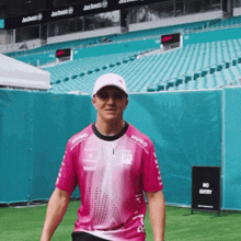 a man wearing a pink shirt that says hugo