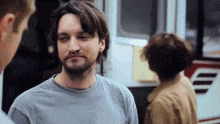 a man with a beard and a nose ring is talking to another man