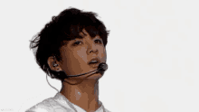a close up of a young man wearing a microphone and earphones .