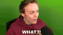 a man in a red hoodie is talking into a microphone and says what ?