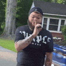 a man with a beard wearing a t-shirt that says ' mxxv ' on it