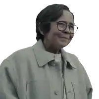a woman wearing glasses and a jacket smiles for the camera