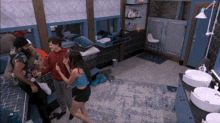 a group of people in a room with two sinks