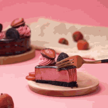 a slice of strawberry cheesecake is being eaten with a gold fork