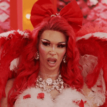 a woman with red hair is wearing a costume with feathers and a bow