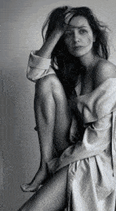 a black and white photo of a woman sitting down