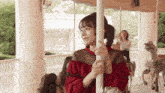 a woman is riding a merry go round in an amusement park .