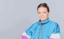 a woman wearing a blue jacket with the word elle on the bottom right