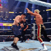 two men are wrestling in a ring with a sign that says wrestlemania in the background